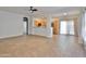 Bright and spacious living room with tile flooring, ceiling fan, and seamless transition to the kitchen at 15354 W Caribbean Ln, Surprise, AZ 85379