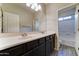 This bathroom boasts a double sink vanity with a large mirror, complemented by modern lighting at 16389 N 180Th Dr, Surprise, AZ 85388