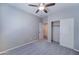Cozy bedroom with neutral walls, plush carpet, ceiling fan, and closet with sliding doors at 16389 N 180Th Dr, Surprise, AZ 85388