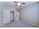 This bedroom features neutral walls, carpet, a ceiling fan, and a closet for storage at 16389 N 180Th Dr, Surprise, AZ 85388
