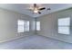 Neutral bedroom with plush carpet, ceiling fan, and large windows providing ample natural light at 16389 N 180Th Dr, Surprise, AZ 85388