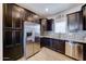 Well-equipped kitchen with stainless steel refrigerator, granite countertops, tile backsplash, and dark cabinets at 16389 N 180Th Dr, Surprise, AZ 85388