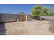 Large backyard with a storage shed, mature trees, and ample room for landscaping or play at 16523 W Desert Bloom St, Goodyear, AZ 85338