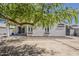 Large backyard featuring a covered patio, mature shade tree and plenty of room for entertaining at 16523 W Desert Bloom St, Goodyear, AZ 85338