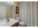 Cozy bathroom featuring a clean white sink, toilet, and a patterned wallpaper accent wall at 16523 W Desert Bloom St, Goodyear, AZ 85338