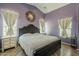 Charming bedroom features a black wood frame bed, neutral linens, and decorative wall mirror at 16523 W Desert Bloom St, Goodyear, AZ 85338