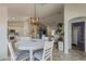 Light and airy dining area flows into the open-concept living room and features a white dining set at 16523 W Desert Bloom St, Goodyear, AZ 85338