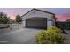 Home's inviting exterior showcasing a two-car garage and easy-care landscaping at 16523 W Desert Bloom St, Goodyear, AZ 85338