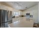Well-lit kitchen with stainless steel appliances, white cabinets, and a view through the window at 16523 W Desert Bloom St, Goodyear, AZ 85338