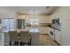 Updated white kitchen features stainless steel appliances, tile floors, and breakfast bar with seating at 16523 W Desert Bloom St, Goodyear, AZ 85338