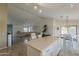 Open concept kitchen flows into the living and dining spaces offering quartz countertops and island seating at 16523 W Desert Bloom St, Goodyear, AZ 85338