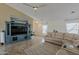 Living room with tile floors, a sectional sofa and entertainment center at 16523 W Desert Bloom St, Goodyear, AZ 85338