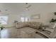 Comfortable living room featuring a sectional sofa, tile floors and lots of light at 16523 W Desert Bloom St, Goodyear, AZ 85338