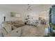 Bright, open-concept living room featuring tile floors, neutral decor, and a ceiling fan at 16523 W Desert Bloom St, Goodyear, AZ 85338