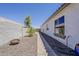 View of the low maintenance side yard with mature landscaping, pavers, and a rock groundcover at 16523 W Desert Bloom St, Goodyear, AZ 85338