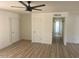 Bright bedroom with hardwood floors, ceiling fan, and a hallway with white trim at 18045 N 20Th N Ln, Phoenix, AZ 85023