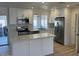Bright kitchen features white cabinets, stainless appliances, and island with marble countertop at 18045 N 20Th N Ln, Phoenix, AZ 85023