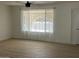 Cozy living room featuring new flooring and a large window providing ample natural light at 18045 N 20Th N Ln, Phoenix, AZ 85023