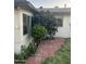Charming side yard featuring brick pavers, lush greenery, and flowering plants, enhancing the home's curb appeal at 18045 N 20Th N Ln, Phoenix, AZ 85023