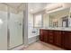Bathroom featuring double vanity, bathtub, and a glass-enclosed shower, all well-lit at 2053 E Saddlebrook Ct, Gilbert, AZ 85298