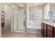 Clean bathroom showcasing a glass shower, soaking tub, and dark wood vanity for storage at 2053 E Saddlebrook Ct, Gilbert, AZ 85298