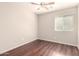 Bright bedroom featuring wood-look floors, ceiling fan and a window with blinds at 2053 E Saddlebrook Ct, Gilbert, AZ 85298