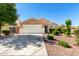 Charming single-story home featuring a well-manicured front yard and a two-car garage at 2053 E Saddlebrook Ct, Gilbert, AZ 85298