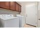 Functional laundry room with a washer, dryer, and overhead storage cabinets at 2053 E Saddlebrook Ct, Gilbert, AZ 85298