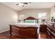 Spacious main bedroom featuring a ceiling fan and an elegant dark wood sleigh bed at 2053 E Saddlebrook Ct, Gilbert, AZ 85298