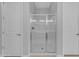 Enclosed glass shower between two white doors in neutral toned bathroom at 22788 E Orion Way, Queen Creek, AZ 85142
