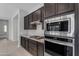Gourmet kitchen with stainless steel appliances, granite countertops, and dark wood cabinetry at 22788 E Orion Way, Queen Creek, AZ 85142