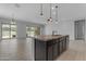 Open concept kitchen with a large island, stainless steel sink, and seamless flow to the living area at 22788 E Orion Way, Queen Creek, AZ 85142