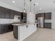 Modern kitchen featuring dark cabinets, granite countertops, stainless steel appliances, and pendant lighting at 22788 E Orion Way, Queen Creek, AZ 85142