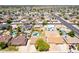 Expansive aerial view of a neighborhood with houses, pools, solar panels, and green lawns under a clear blue sky at 2338 E Javelina Ave, Mesa, AZ 85204
