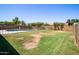 Expansive backyard featuring lush green grass, a fenced pool area, and mature trees, offering privacy and space at 2338 E Javelina Ave, Mesa, AZ 85204