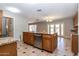 Kitchen island featuring a sink, dishwasher, granite countertop, and wooden cabinetry at 2338 E Javelina Ave, Mesa, AZ 85204