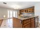 Kitchen island featuring a sink, dishwasher, granite countertops, and wooden cabinetry at 2338 E Javelina Ave, Mesa, AZ 85204