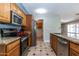 Spacious kitchen featuring stainless steel appliances, granite counters, ample wood cabinetry, and tile flooring at 2338 E Javelina Ave, Mesa, AZ 85204