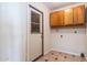 Functional laundry room with overhead cabinets and tile flooring; door to the outside at 2338 E Javelina Ave, Mesa, AZ 85204