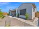 A private backyard featuring desert landscaping, a covered patio with outdoor seating, and lush greenery at 27667 W Mohawk Ln, Buckeye, AZ 85396