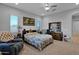 Inviting bedroom with carpeted floors, a ceiling fan, and a floral-patterned bedspread at 27667 W Mohawk Ln, Buckeye, AZ 85396