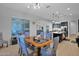 Bright dining area with a wood table, cushioned chairs, and views of the kitchen at 27667 W Mohawk Ln, Buckeye, AZ 85396