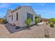 Exterior elevation featuring a gravel yard, covered patio, and desert plants at 27667 W Mohawk Ln, Buckeye, AZ 85396