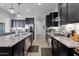 Modern kitchen featuring a large island, granite countertops, and black cabinets at 27667 W Mohawk Ln, Buckeye, AZ 85396