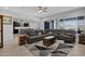 Open-concept living room with tile floors and a large sectional couch for relaxing at 27667 W Mohawk Ln, Buckeye, AZ 85396