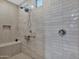 Bright shower featuring tile walls, handheld shower head, and built in bench at 27667 W Mohawk Ln, Buckeye, AZ 85396