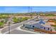 An aerial view showing a street, solar panels on the roof of the house, and open land beyond at 27667 W Mohawk Ln, Buckeye, AZ 85396