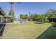 Expansive backyard featuring a fenced pool, lush lawn, mature trees, and charming patio, creating a serene outdoor oasis at 314 E Royal Palm Rd, Phoenix, AZ 85020