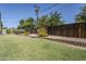 Picturesque backyard with a wooden fence, mature shrubs, vibrant flowers, and a well-maintained lawn offering privacy at 314 E Royal Palm Rd, Phoenix, AZ 85020