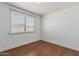 Simple bedroom with wood floors, window, baseboards, and white paint at 343 W Santa Cruz Dr, Tempe, AZ 85282